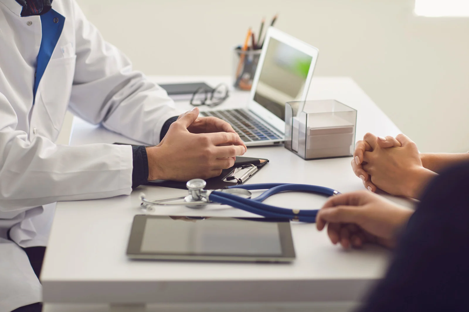 Confident Doctor and Couple Patient Sitting at the Table in Clinic Office