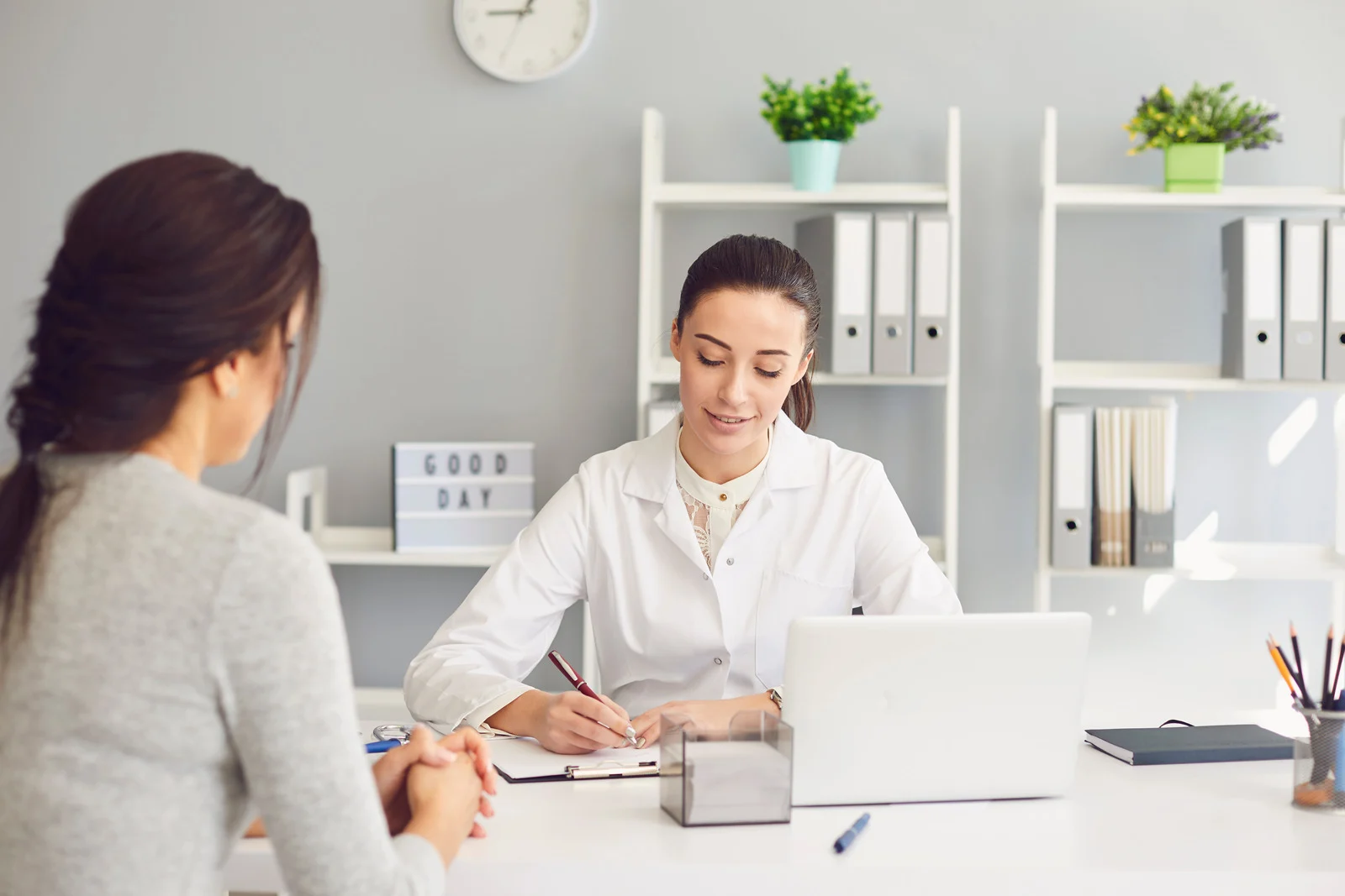 Woman patient visiting female doctor at clinic office